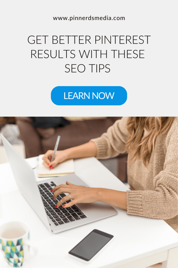 Woman at a white table working on a laptop, writing notes, with a smartphone and coffee mug beside her, learning Pinterest SEO tips.