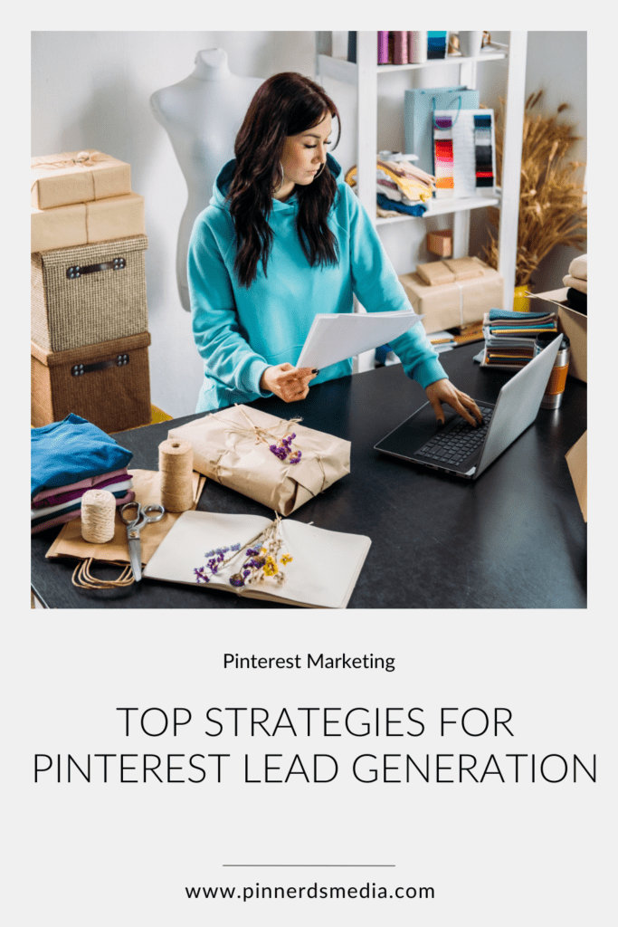 A woman in a blue hoodie working on a laptop in a creative studio, reviewing a document, with packaging materials around, titled 'Top Strategies for Pinterest Lead Generation'.
